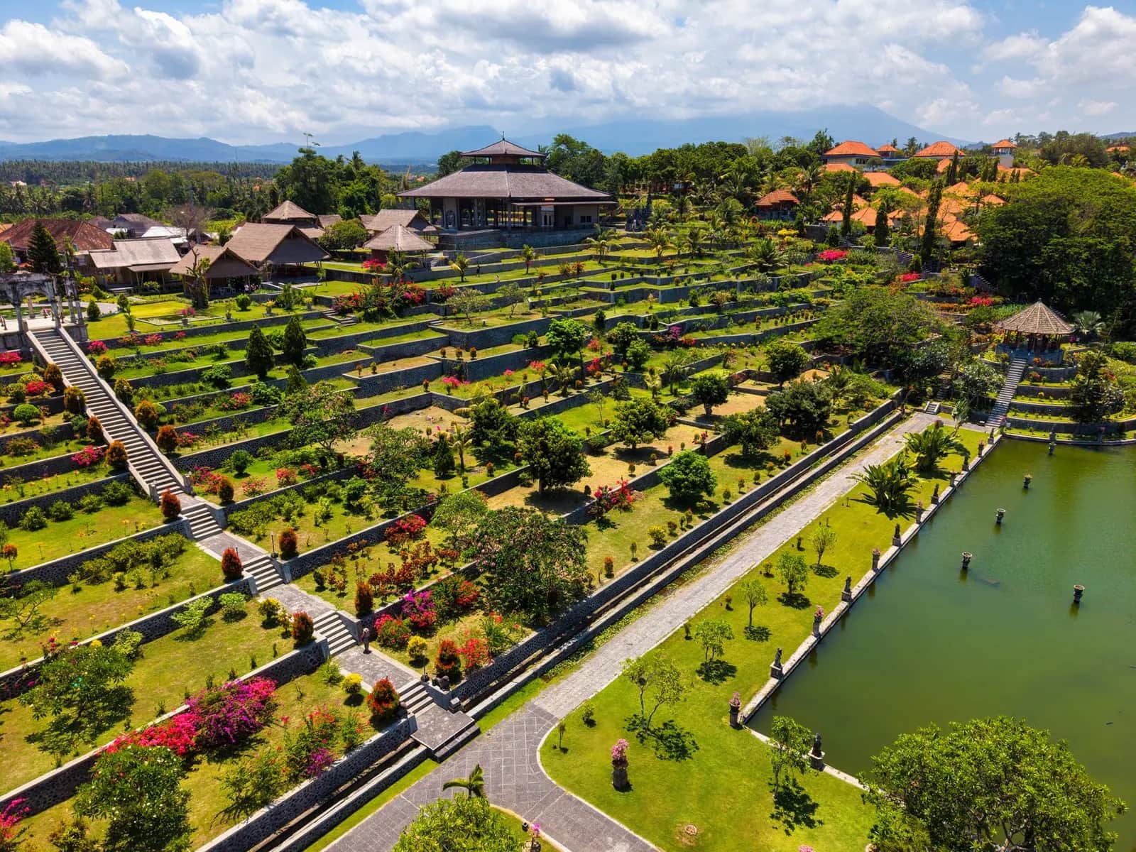 Vue aérienne d'un palais d'eau de Karangasem : jardins en terrasses, bassin bordé de statues et pavillon central, est de Bali