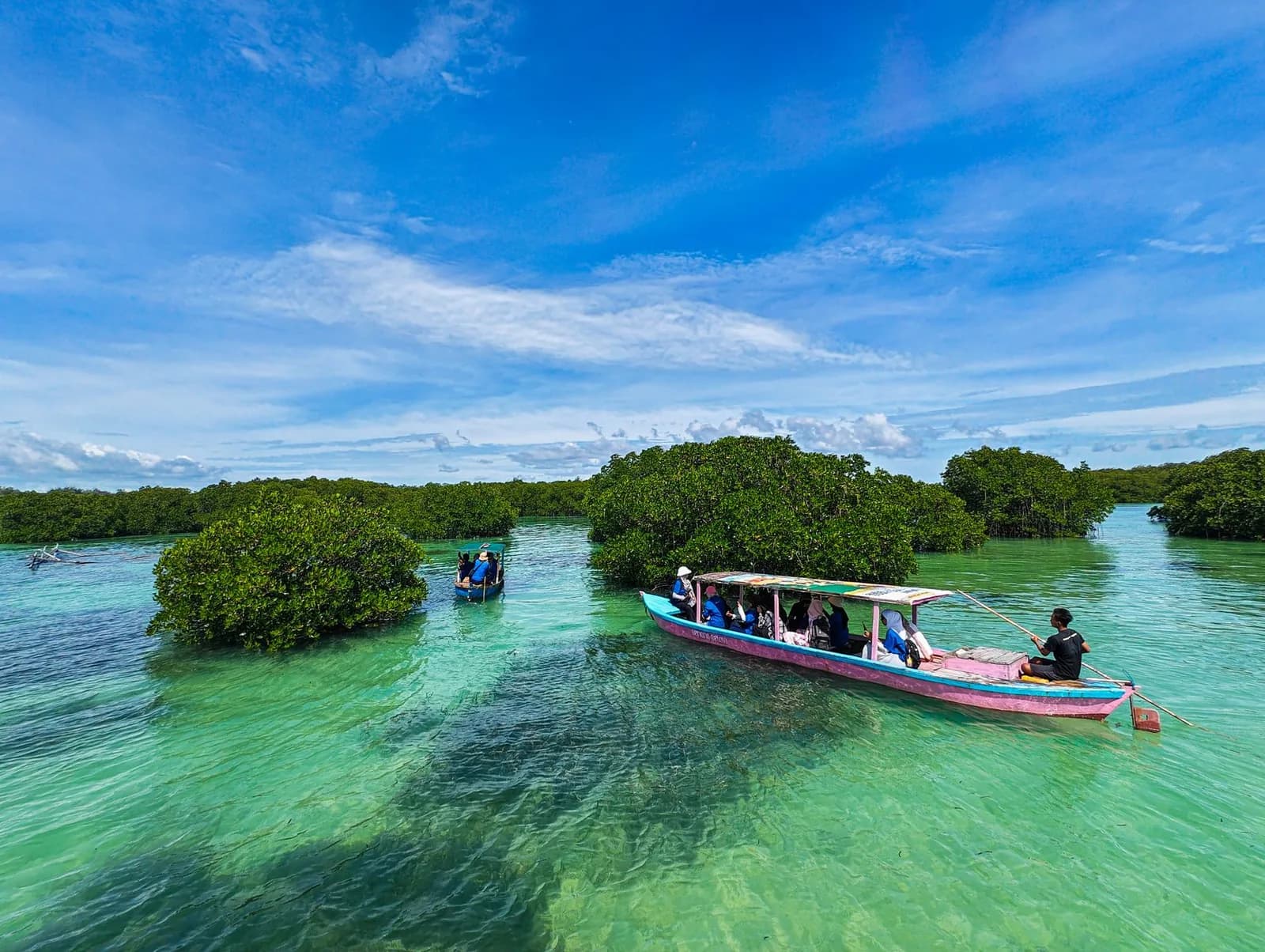 Barque traditionnelle entre les îlots de mangrove sur une eau turquoise, à Bali