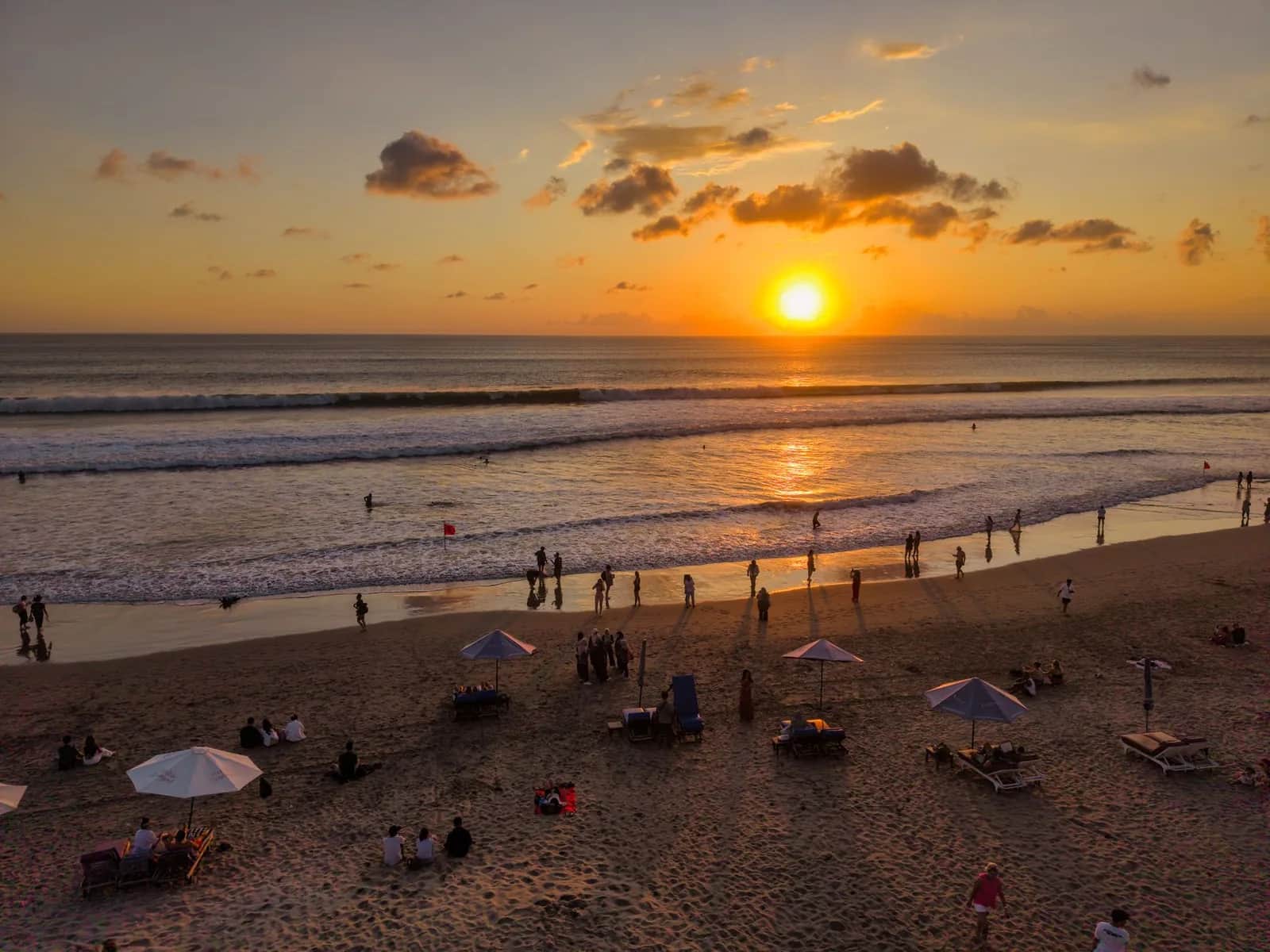 Transats face à l'océan dans un beach club de Canggu au coucher du soleil, Bali