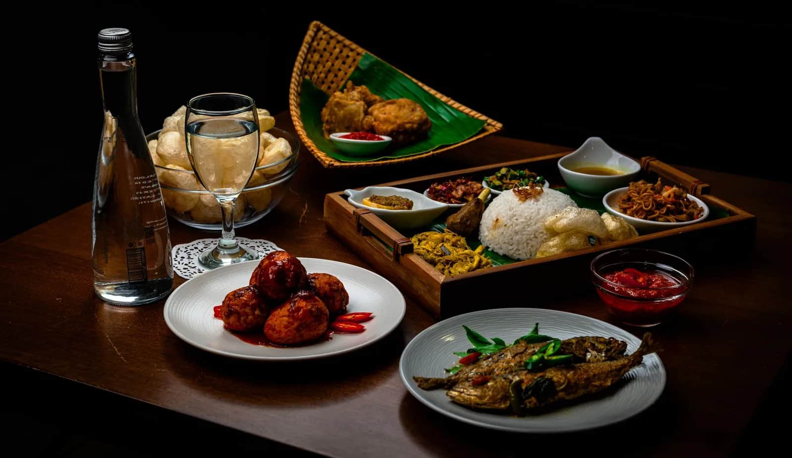 Table de cuisine indonésienne : plateau de nasi padang, boulettes au sambal et poisson grillé