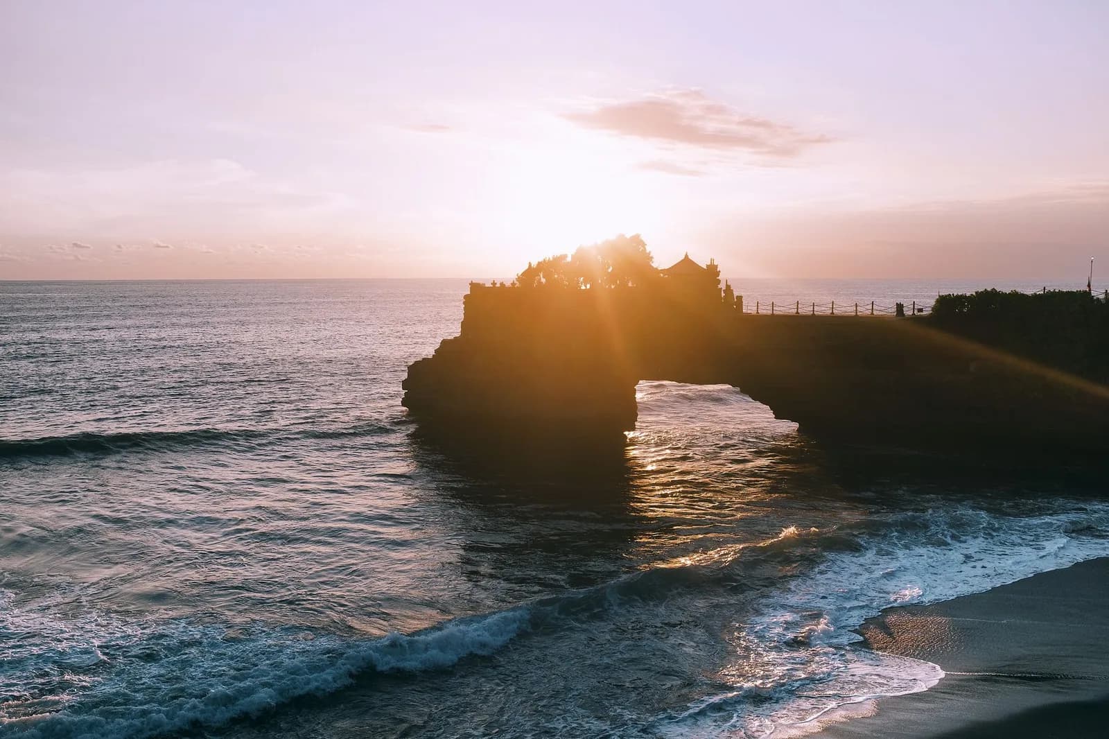 Coucher de soleil derrière le temple de Tanah Lot, sur la côte ouest de Bali