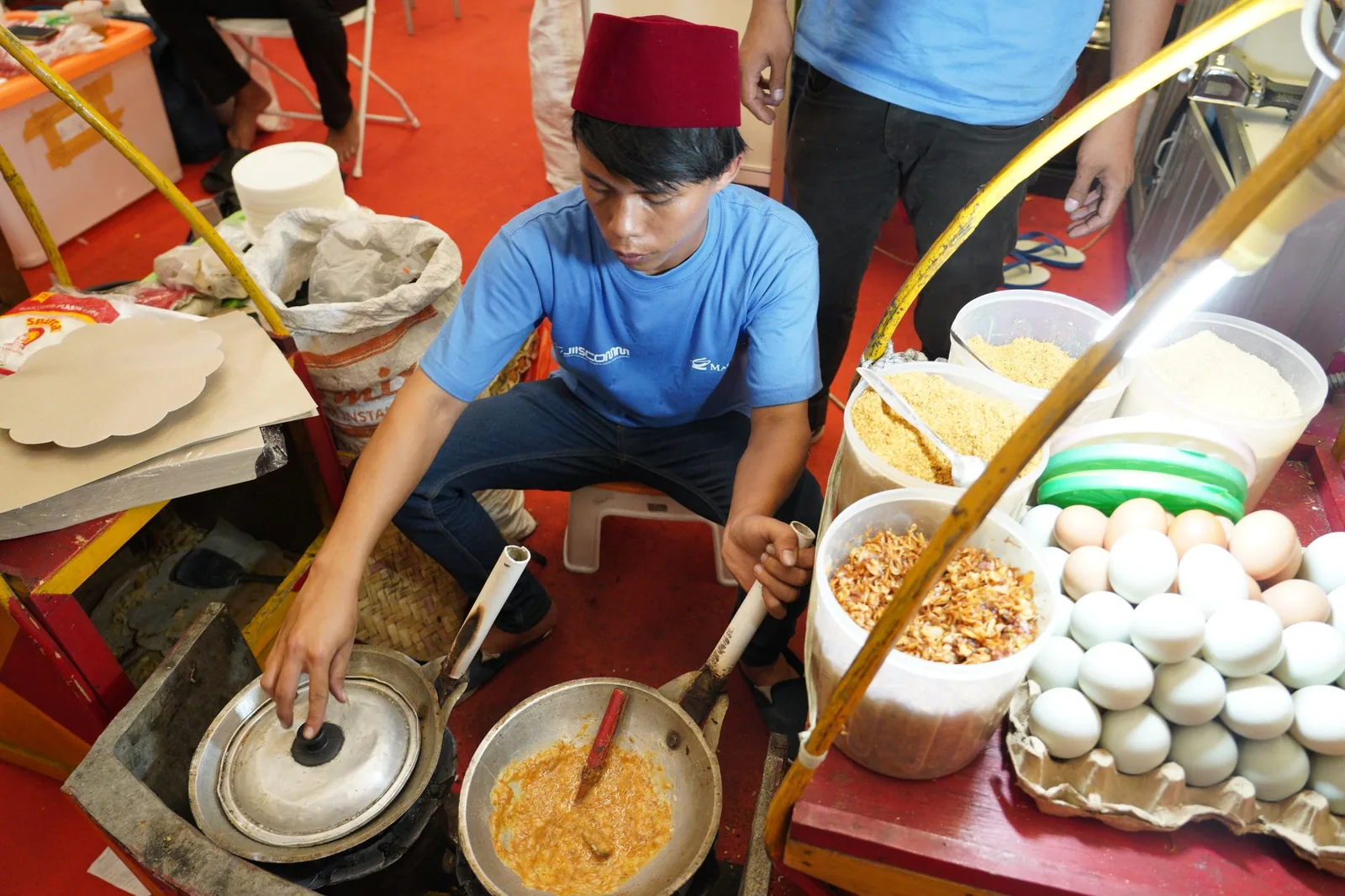 Vendeur de kerak telor cuisant des omelettes de riz sur un brasero à Jakarta