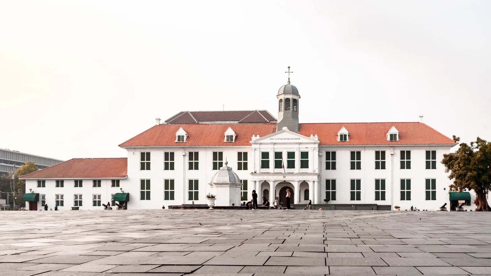 Façade blanche du musée Fatahillah sur la place pavée de Kota Tua à Jakarta