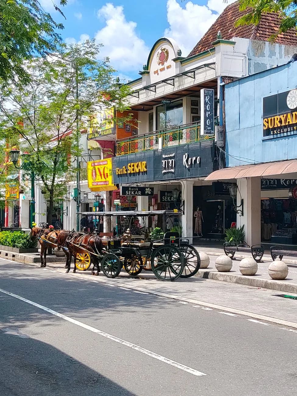Une calèche andong garée devant les boutiques de la rue Malioboro, Yogyakarta