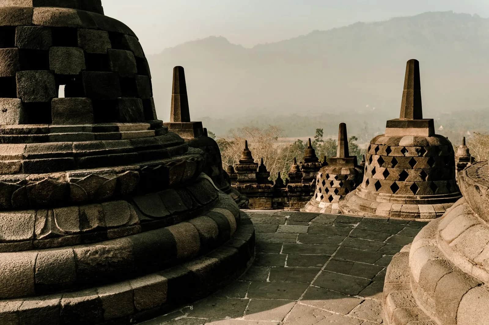 Stupas ajourés sur la terrasse supérieure de Borobudur, collines de Java central dans la brume
