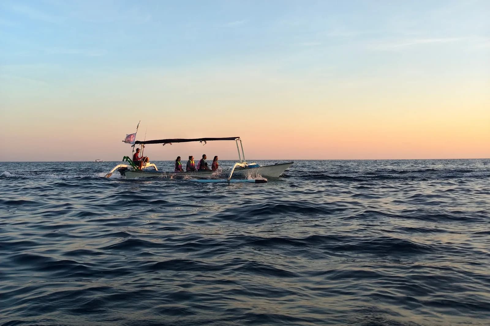 Barque traditionnelle emmenant voir les dauphins au lever du soleil au large de Lovina, nord de Bali