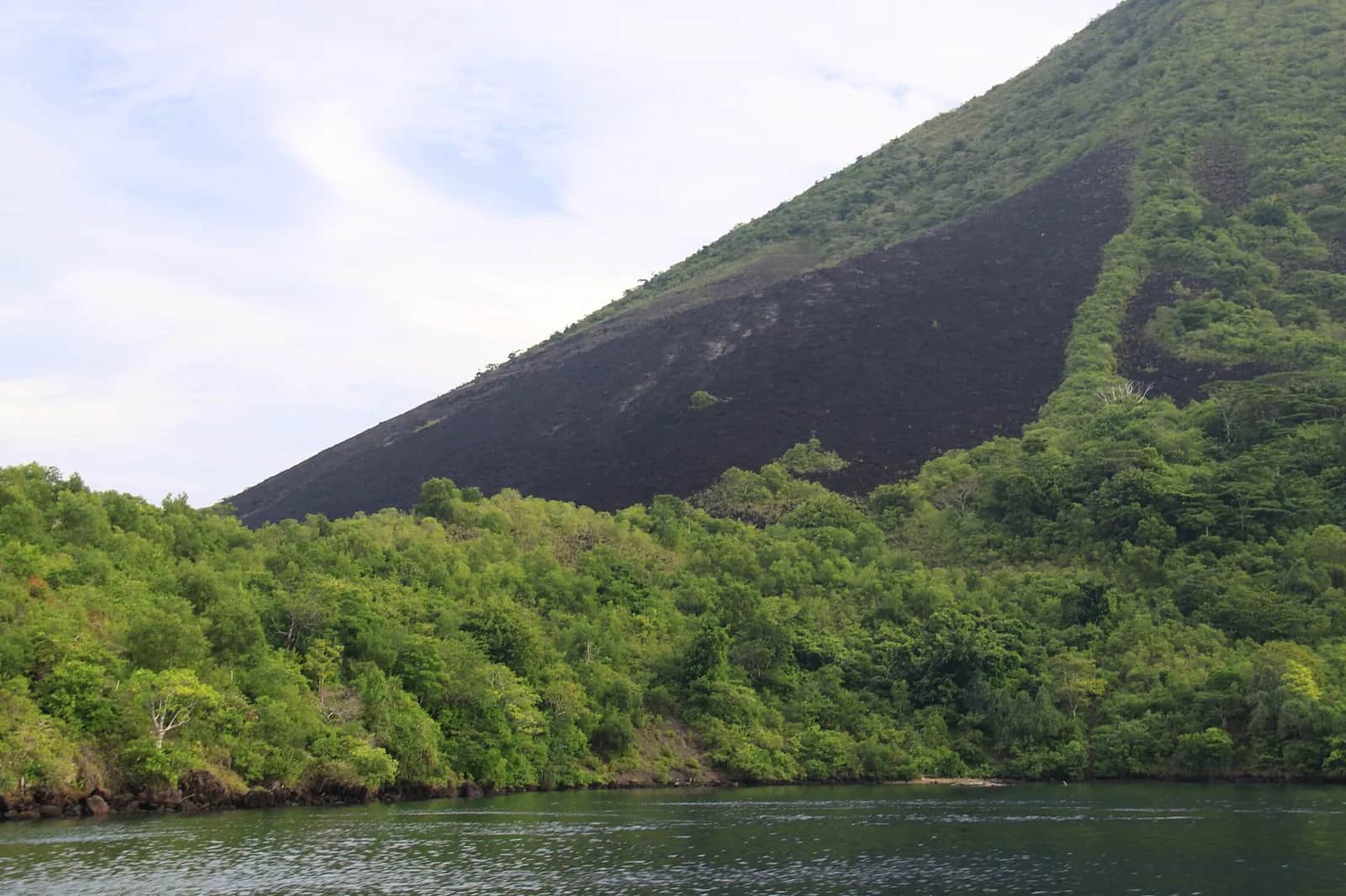 Flanc du volcan Gunung Api et sa coulée de lave noire au-dessus de la mer, aux îles Banda dans les Moluques