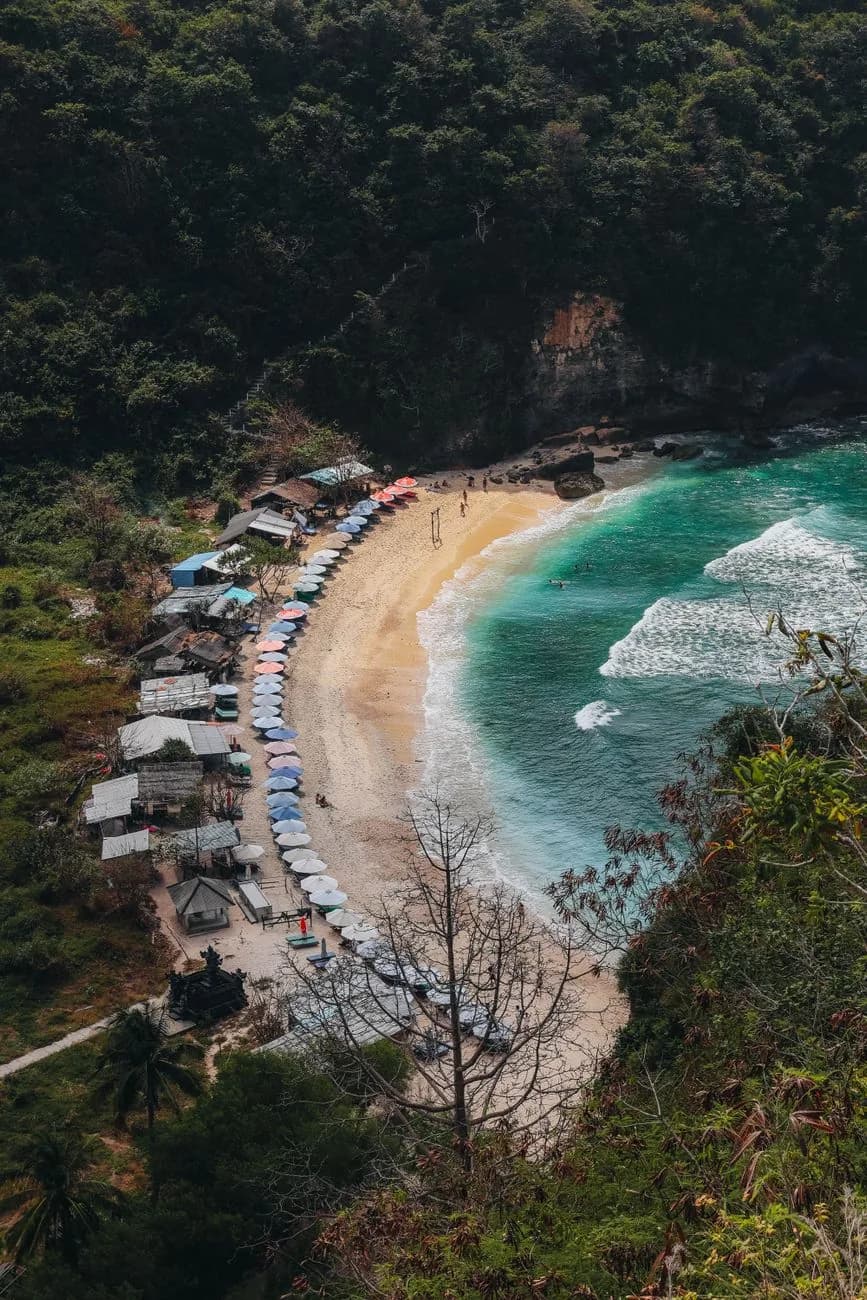 La crique d'Atuh Beach vue d'en haut, avec ses warungs et ses parasols, côte est de Nusa Penida