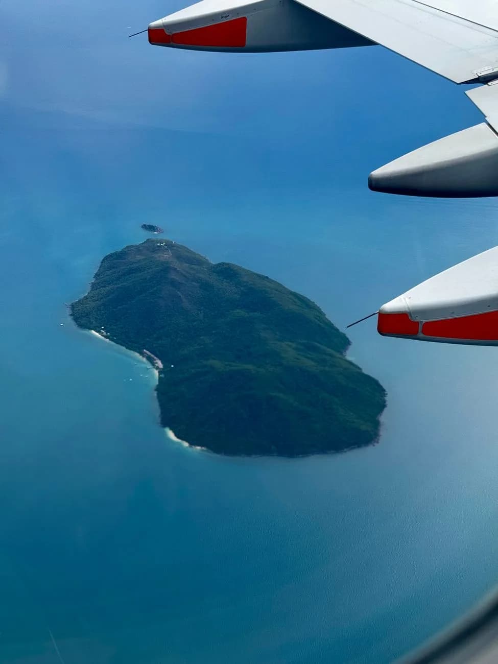 Île tropicale vue depuis le hublot d'un avion