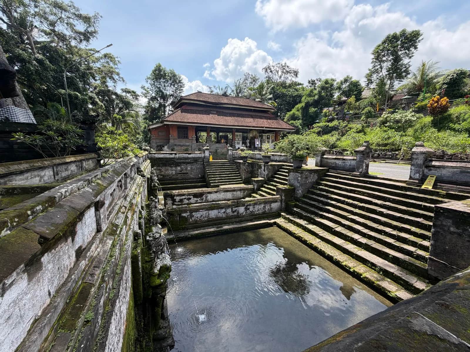 Bassin d'eau, marches de pierre et pavillon balinais dans l'enceinte du temple de Tirta Empul près d'Ubud
