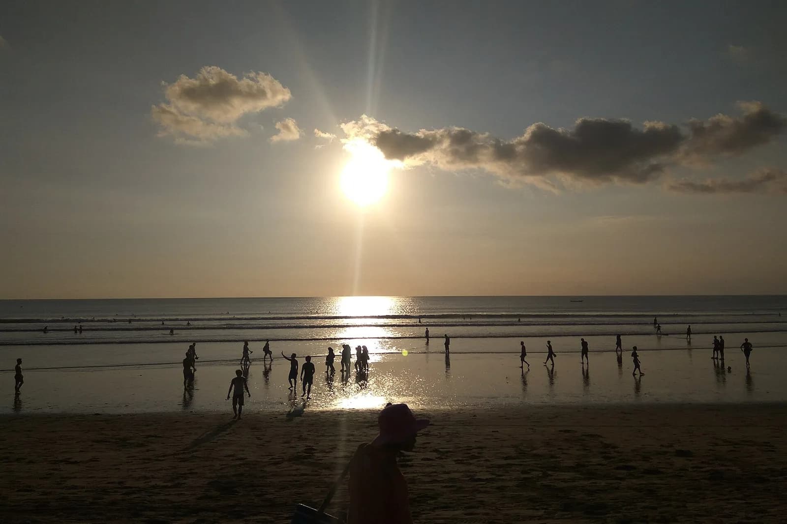 Baigneurs au coucher du soleil sur la plage de Kuta, Bali