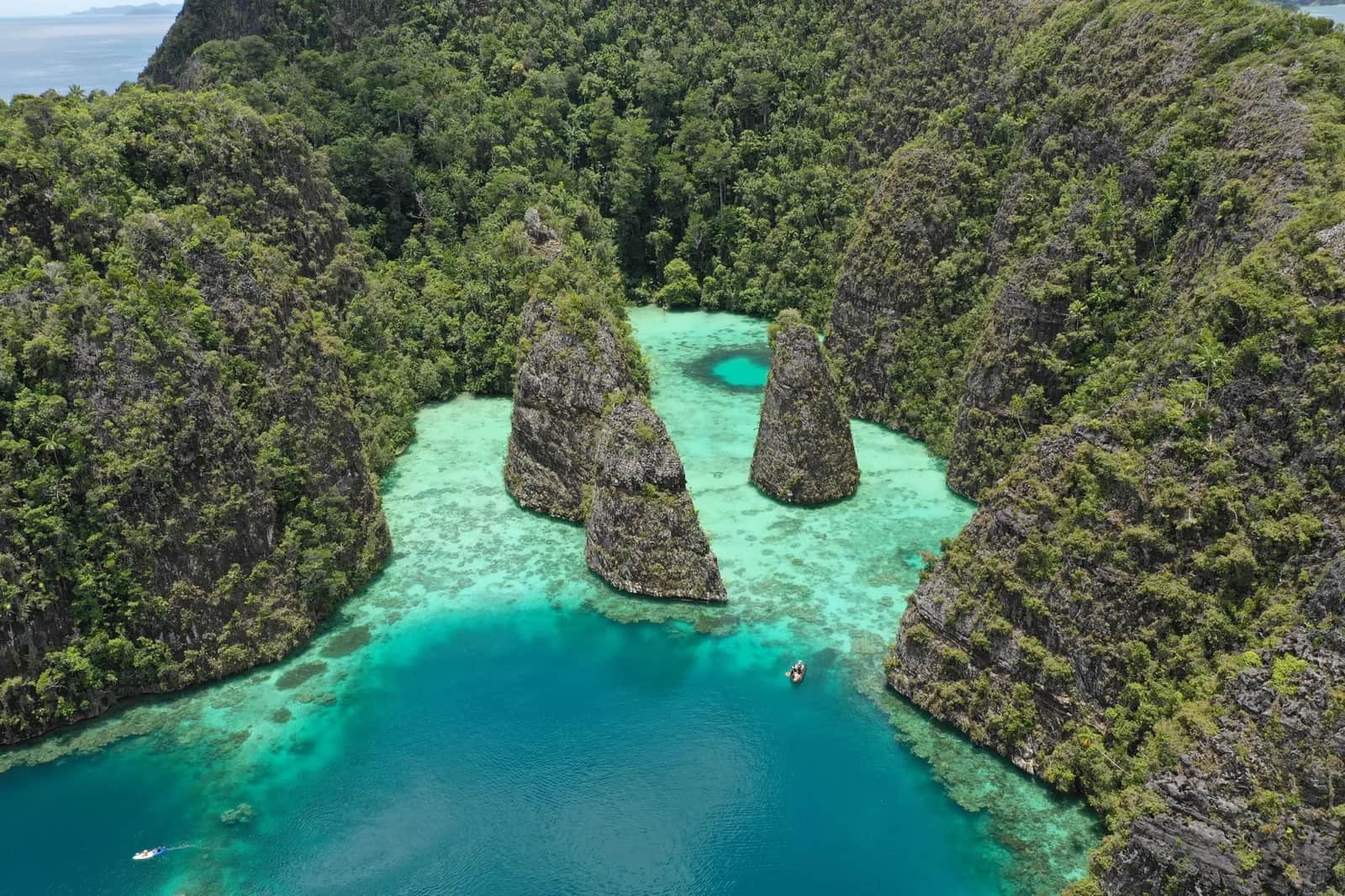 Vue aérienne de pitons karstiques couverts de jungle sur un lagon turquoise, paysage typique du nord de Raja Ampat