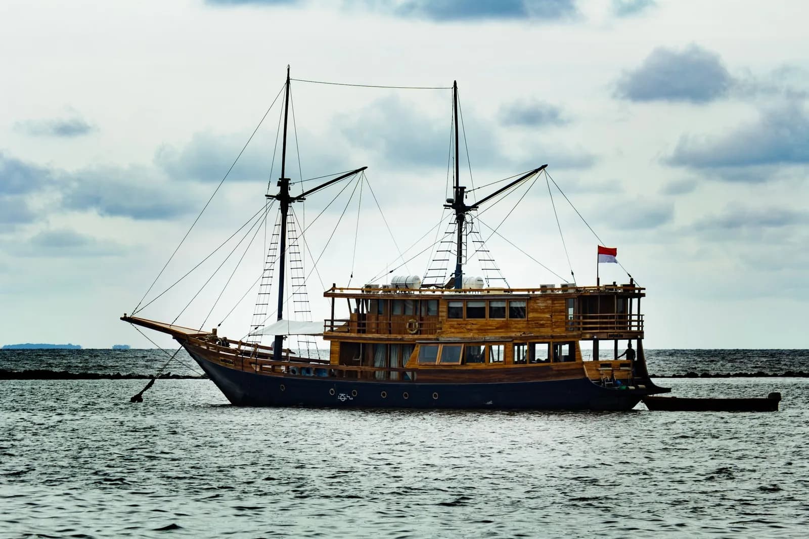 Phinisi en bois à deux mâts battant pavillon indonésien, au mouillage, type de bateau des croisières plongée de Raja Ampat