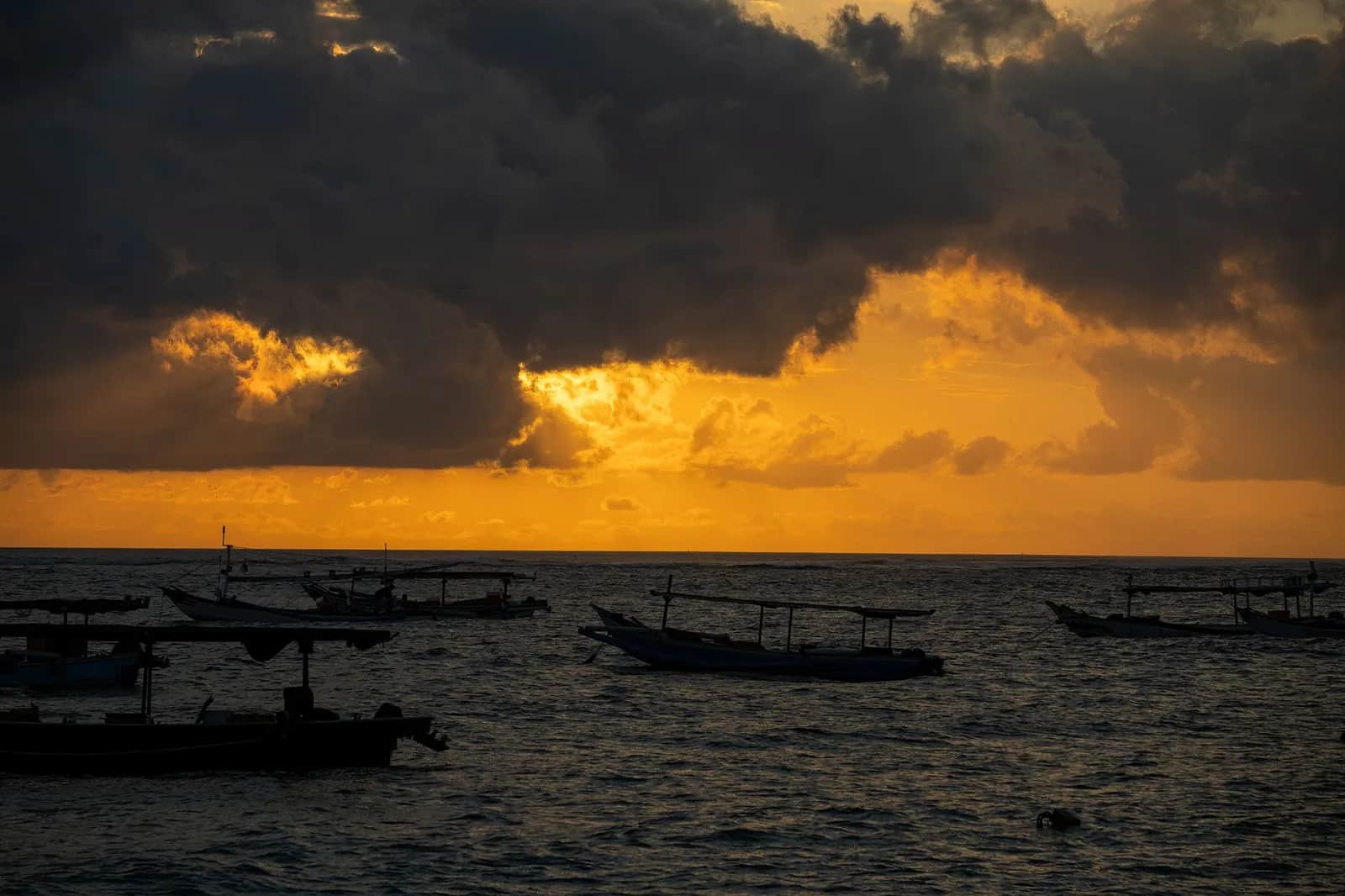Bateau traditionnel balinais sur l'océan au coucher du soleil, Bali