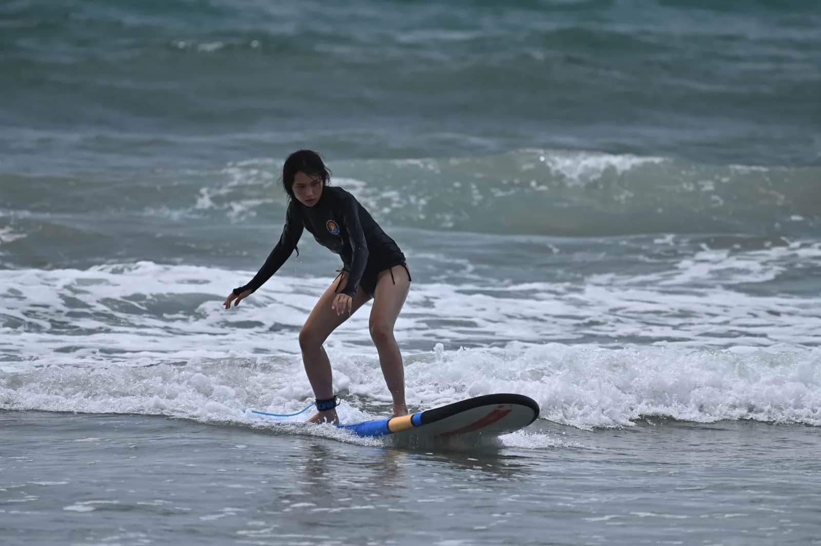 Débutante en cours de surf sur une vague de sable à Bali