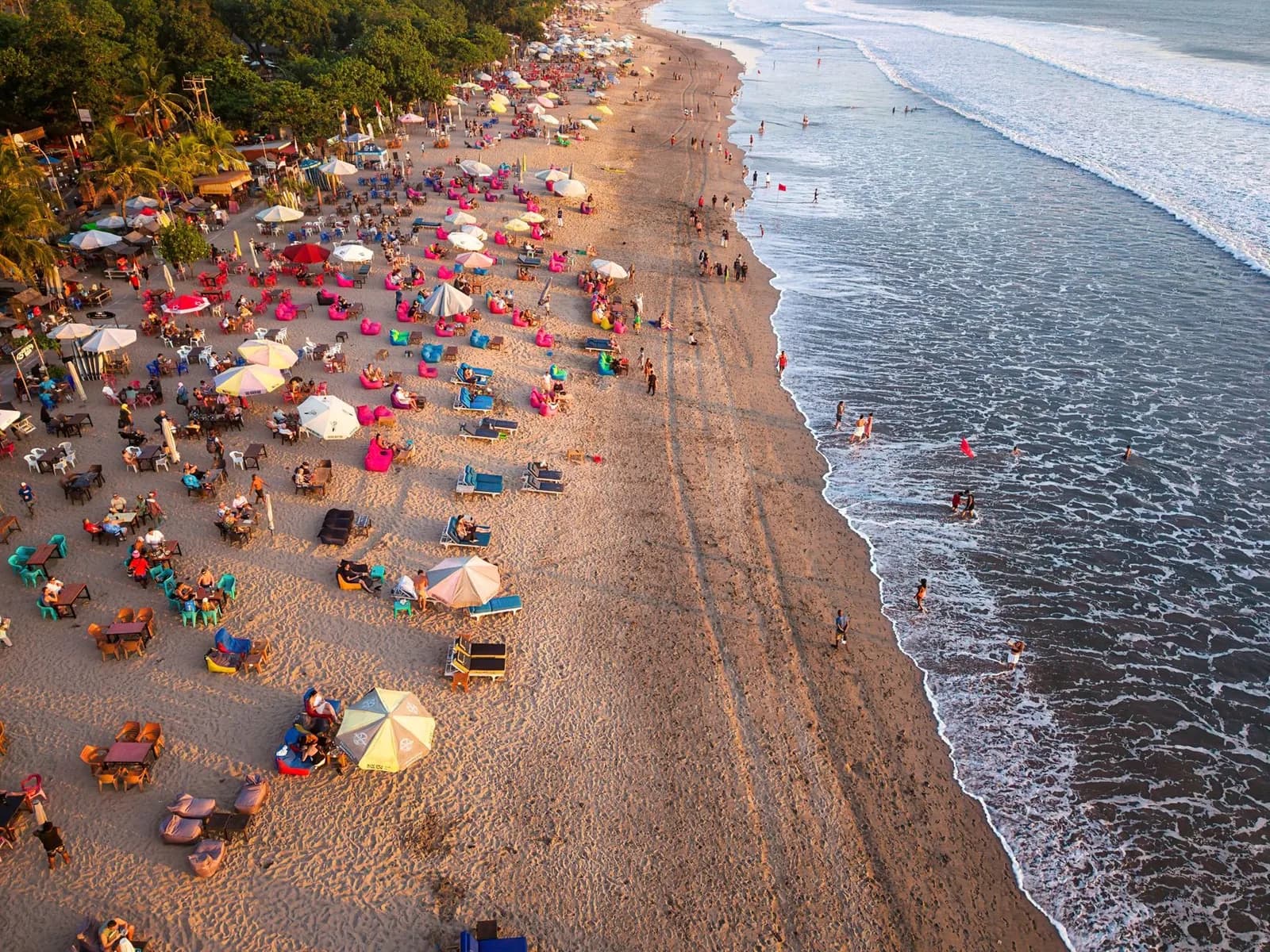 Vue aérienne des bars de plage et beanbags colorés de Seminyak à l'heure dorée, Bali