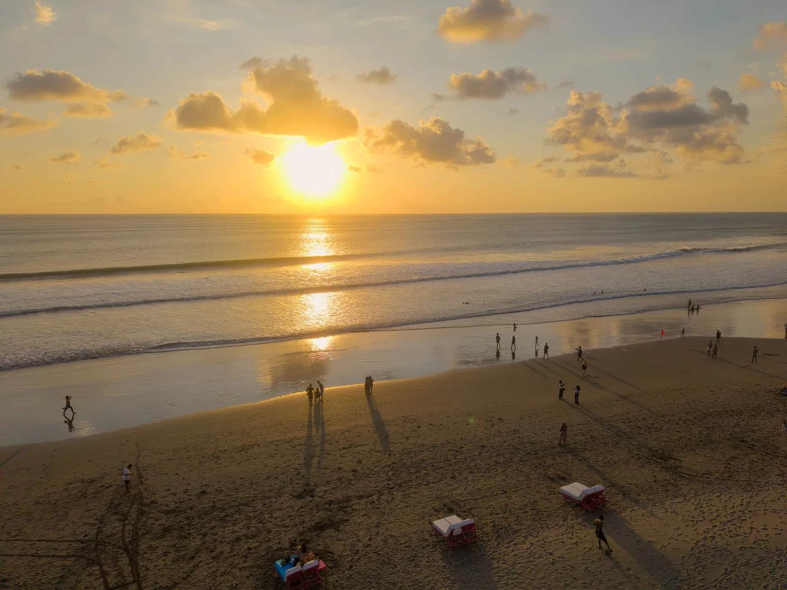 Plage de Seminyak à Bali au coucher du soleil, transats face à l'océan et ciel doré