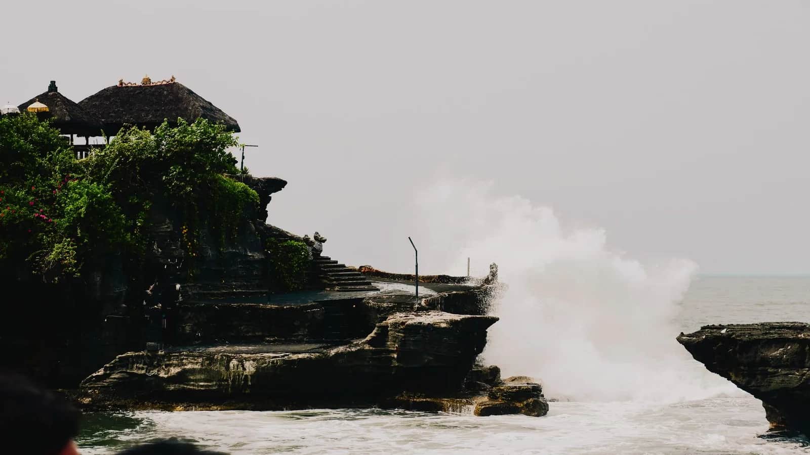 Une grosse vague qui explose contre le rocher du temple de Tanah Lot à marée haute, Bali