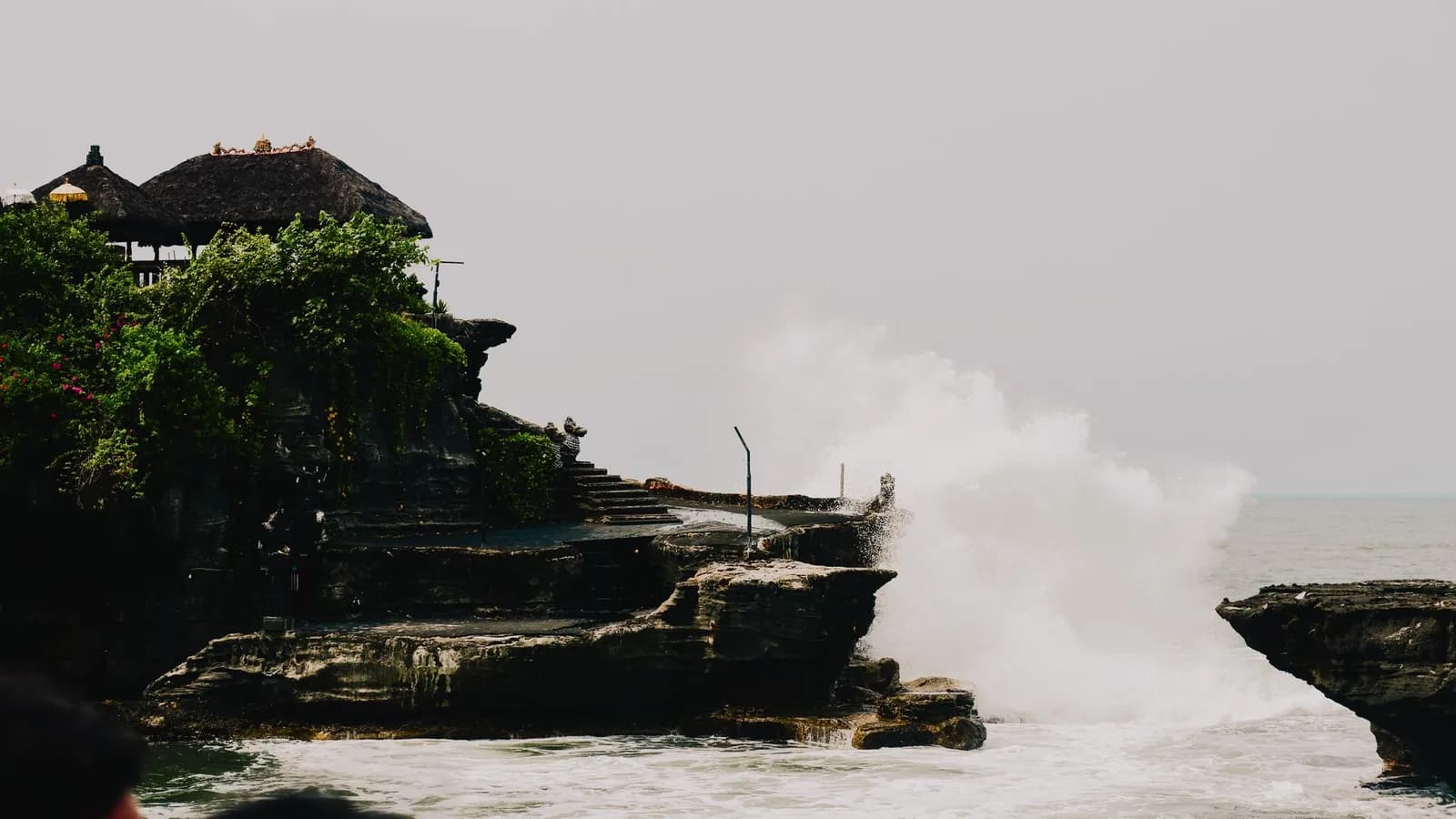 Une grosse vague qui explose contre le rocher du temple de Tanah Lot à marée haute, Bali