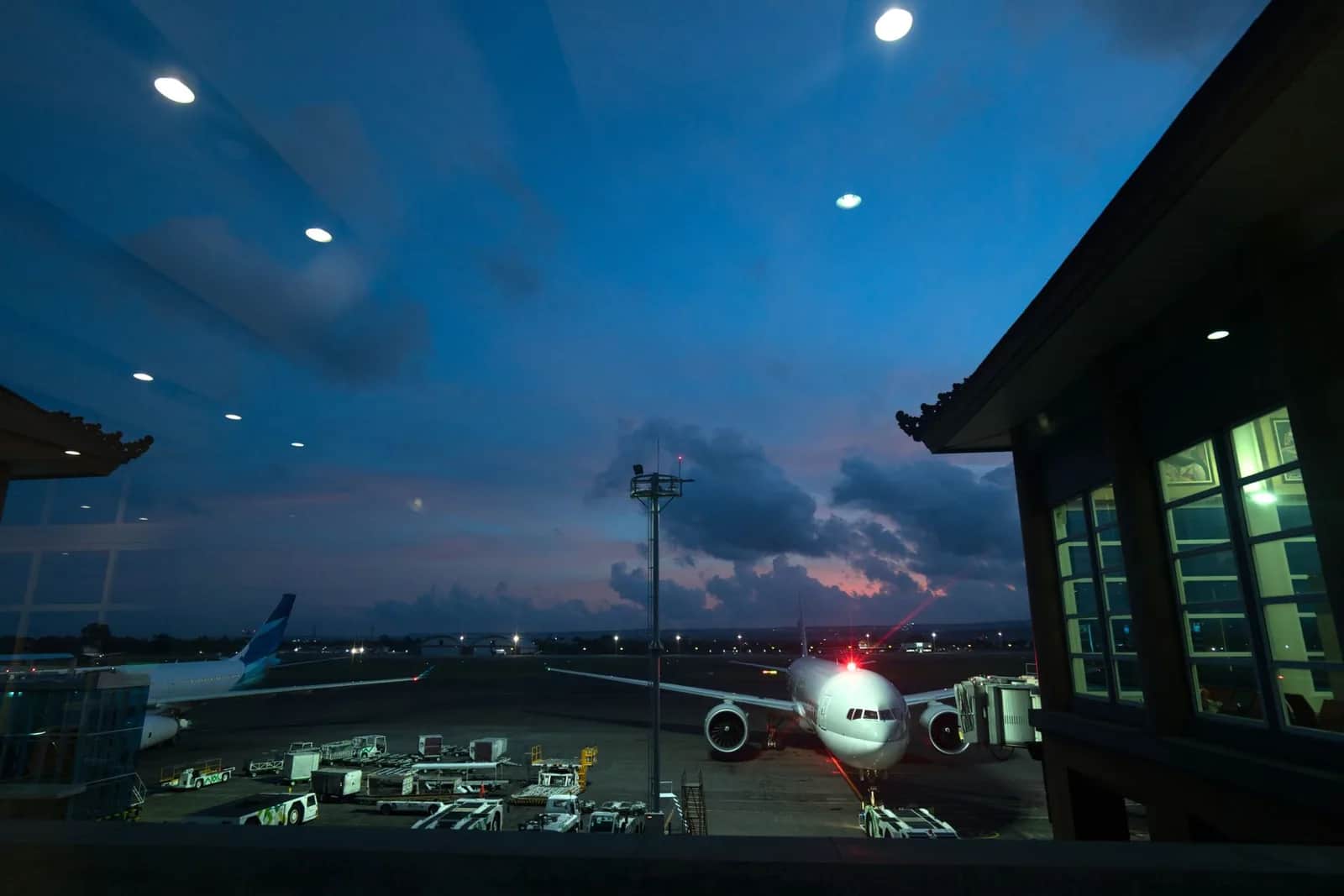 Avions au terminal de l'aéroport international de Denpasar à la tombée de la nuit, Bali