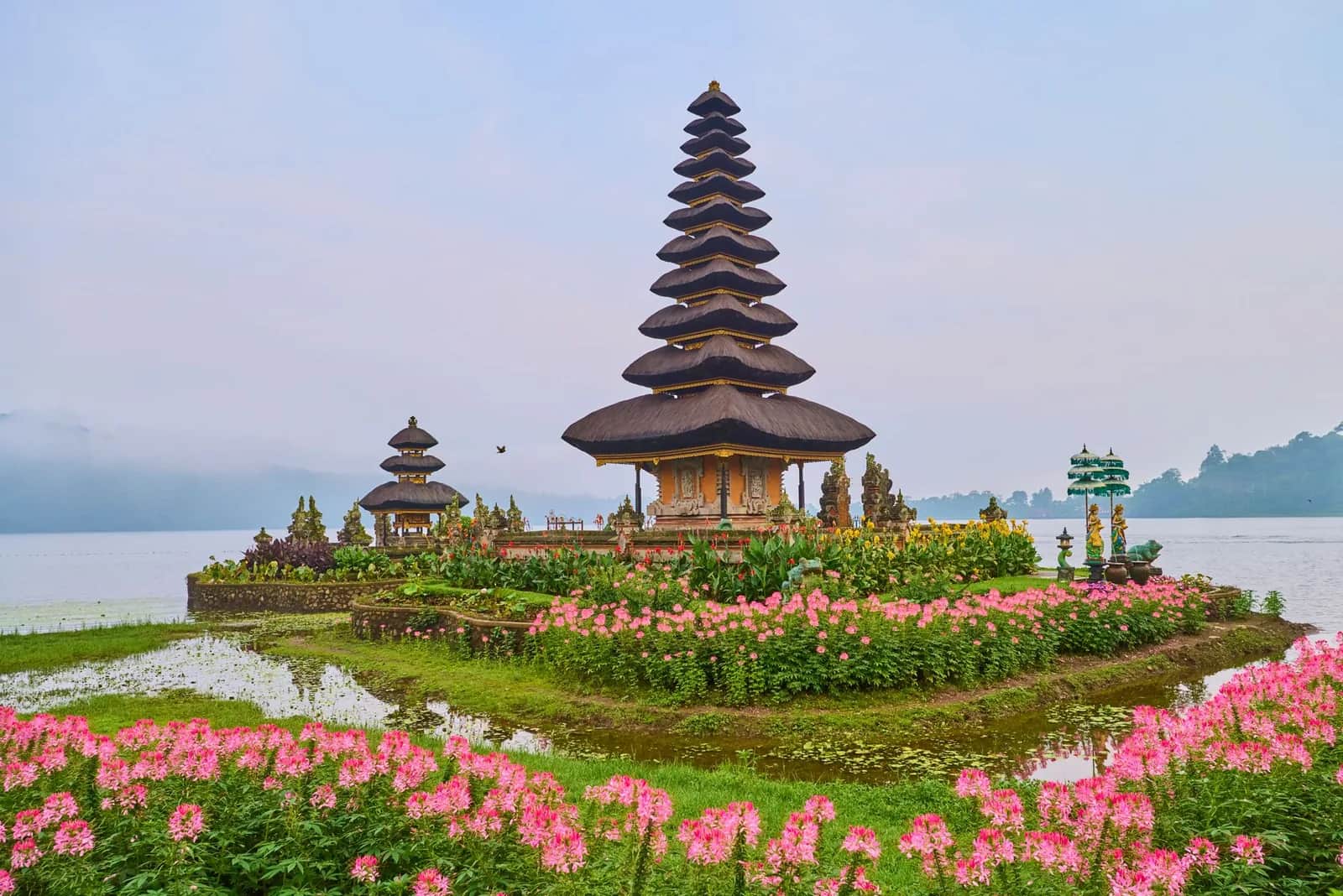 Le meru à 11 étages du temple Ulun Danu Beratan entouré de jardins fleuris et de brume matinale sur le lac Bratan, Bali