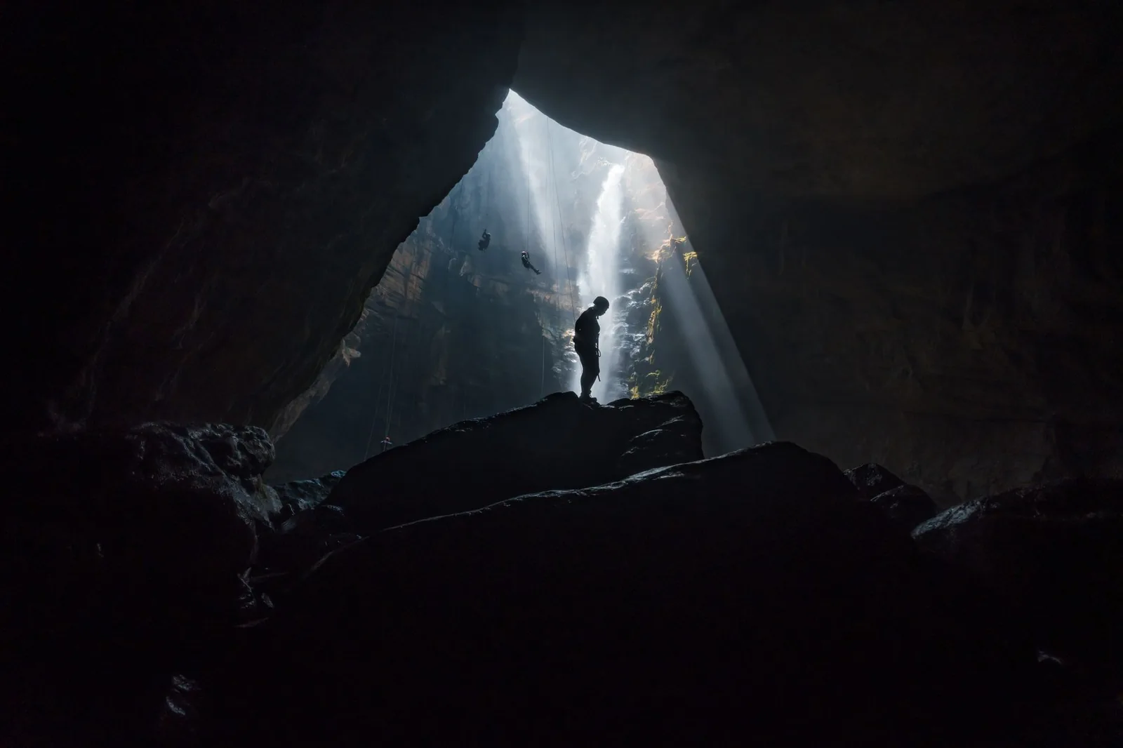 Silhouette d'un visiteur face au rayon de lumière dans la grotte de Jomblang, à Gunungkidul