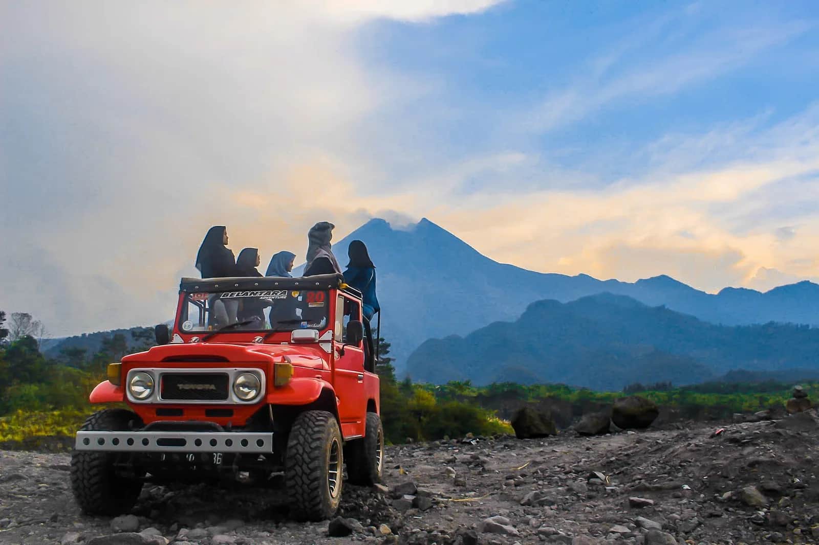Jeep rouge du lava tour sur les coulées de lave du Merapi, avec le volcan en arrière-plan