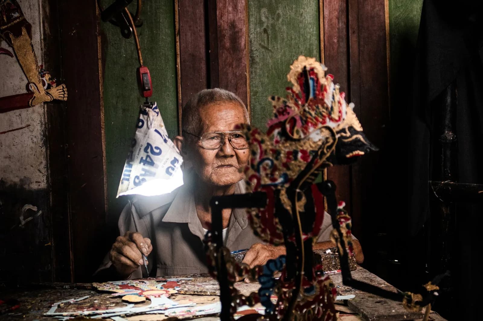 Artisan de Yogyakarta façonnant des marionnettes wayang kulit en cuir dans son atelier