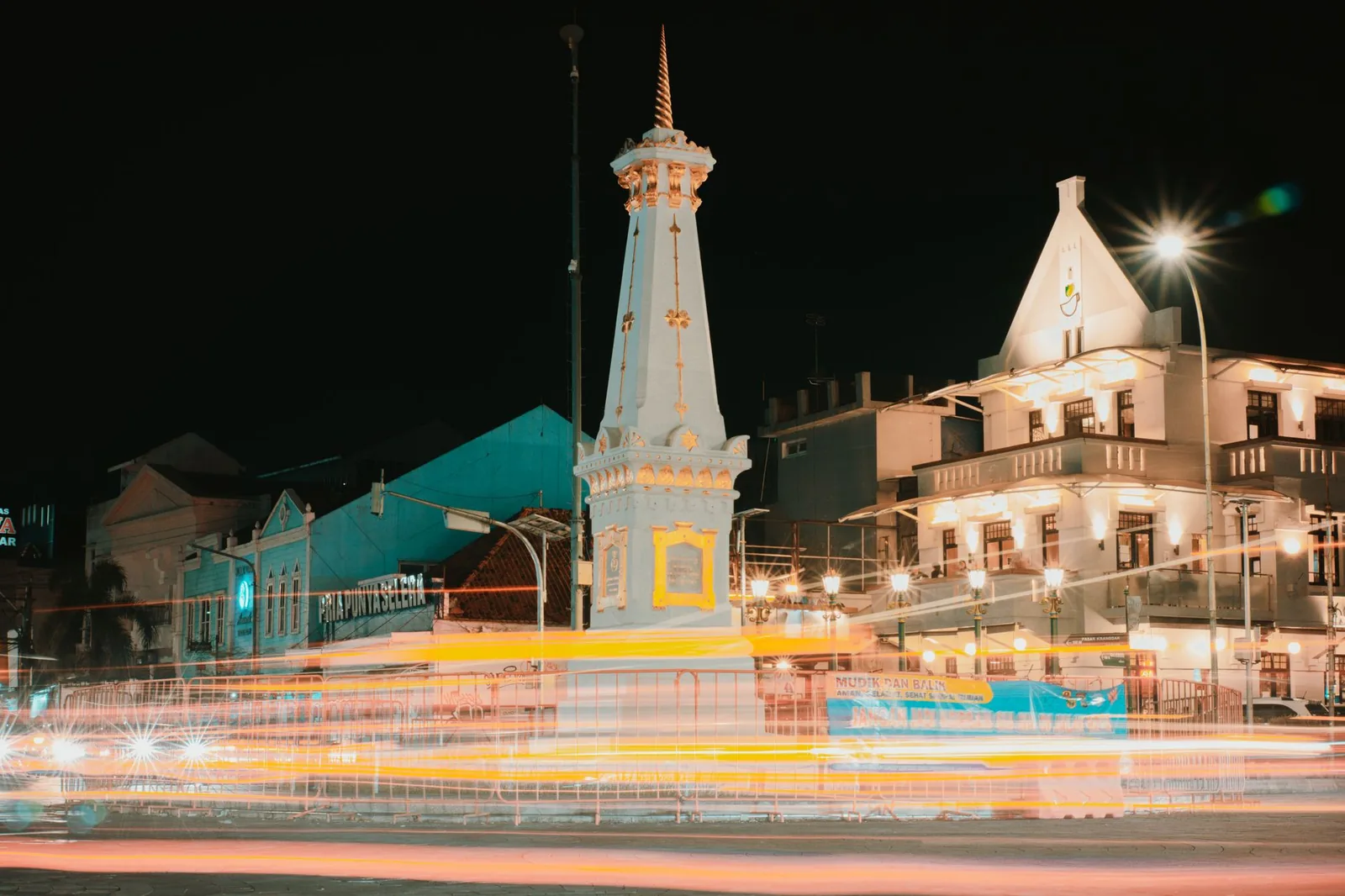 Monument Tugu de Yogyakarta de nuit, avec des traînées de lumière sur la route